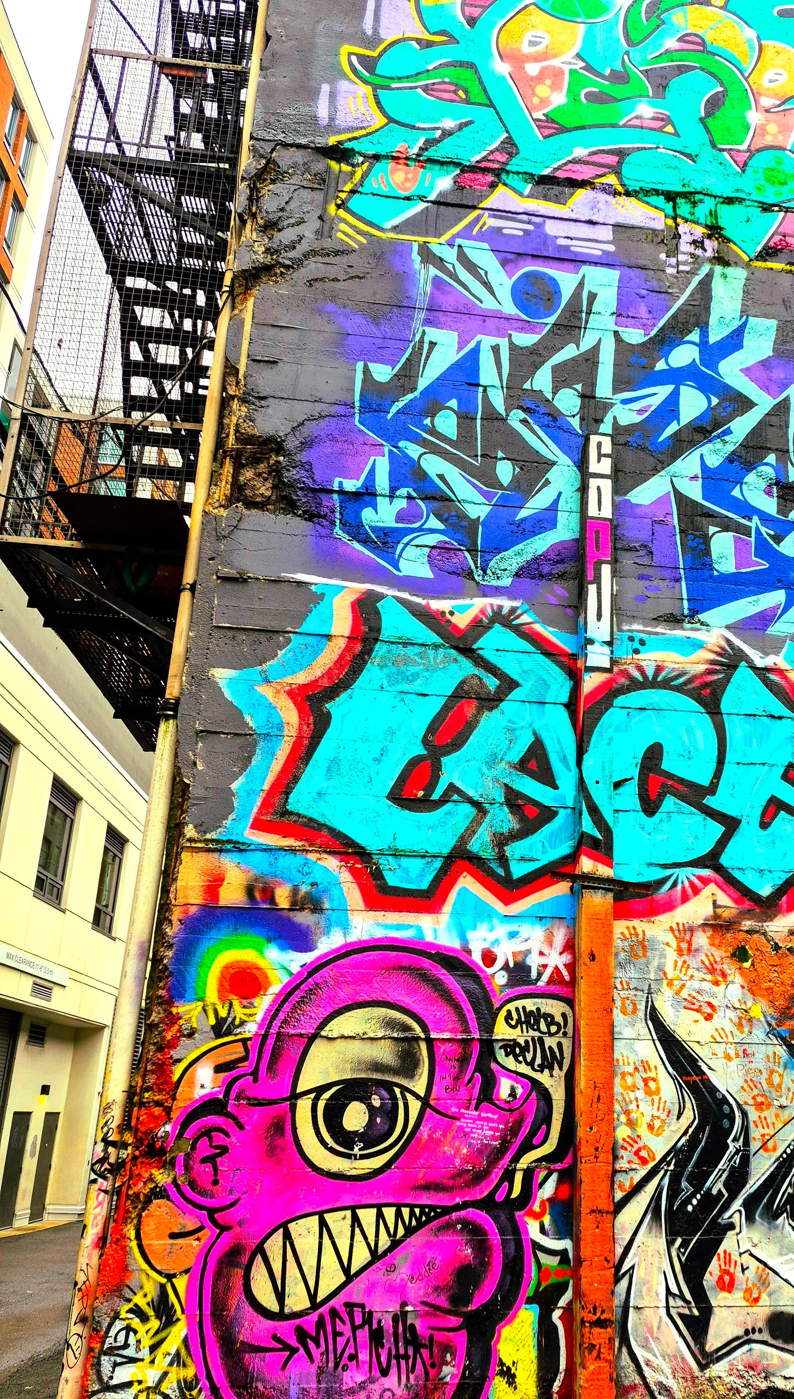 A laneway wall in the Downtown Eastside layered with paint